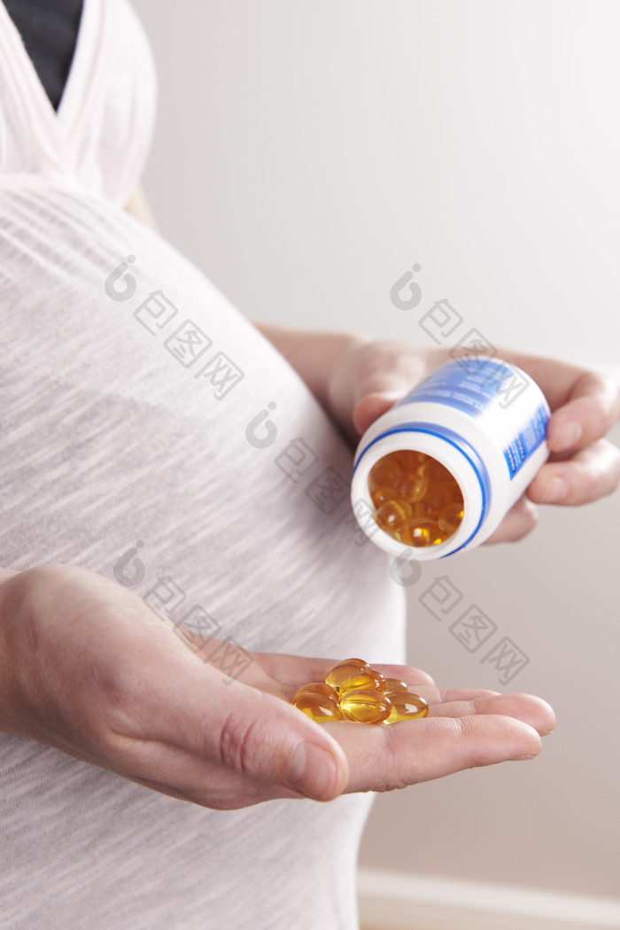 孕妇拿着胶囊维生素
