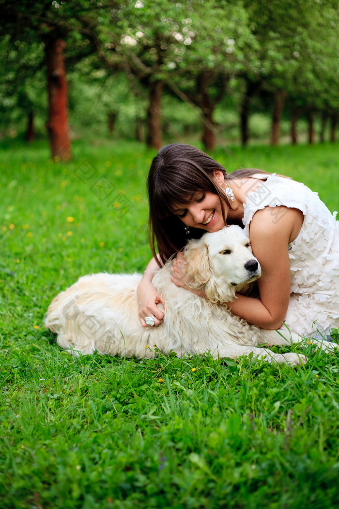 草地上抱着狗的女人