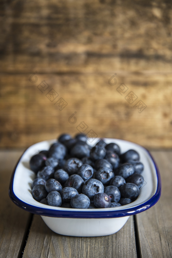 暗色调一小盘蓝莓摄影图