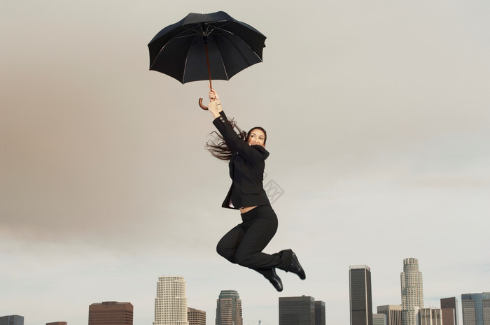 空中撑伞下降的女人图片