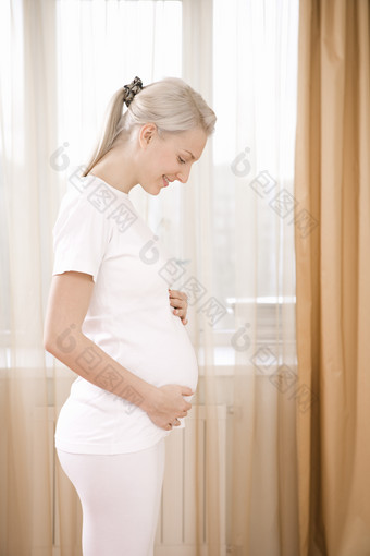 窗帘前的孕妇摄影图
