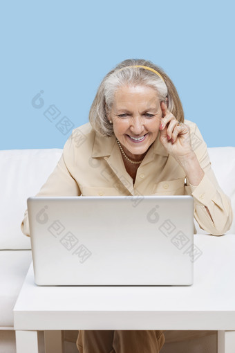 蓝色调打电脑的老女人摄影图
