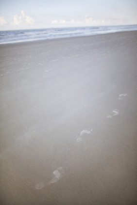 简约沙滩上的脚印摄影图
