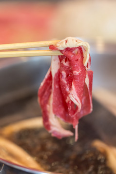 筷子上的羊肉片摄影图