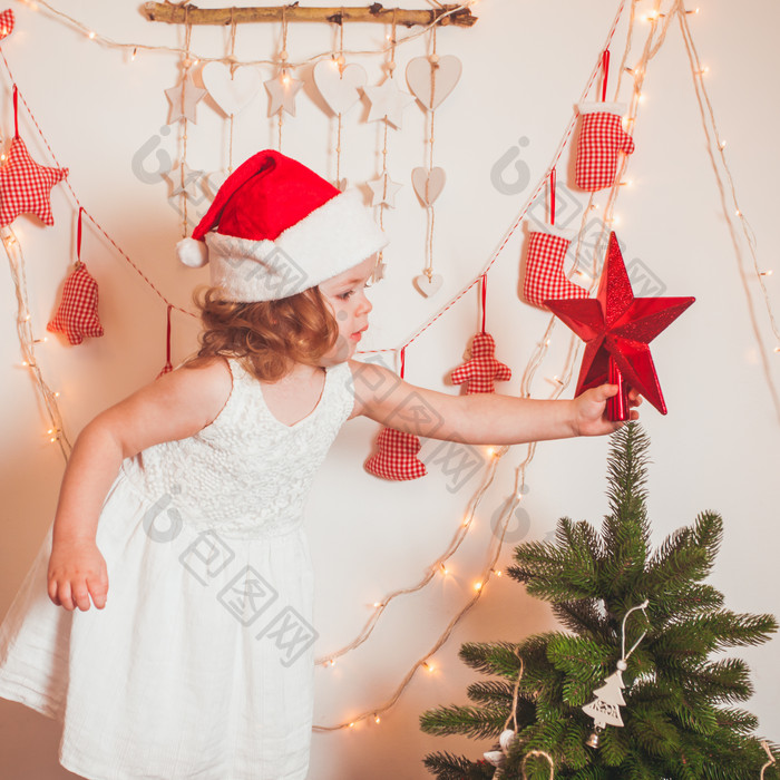 圣诞树装饰星星的小女孩