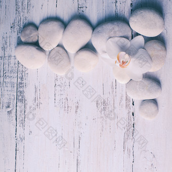 木板上的鹅卵石和白色小花