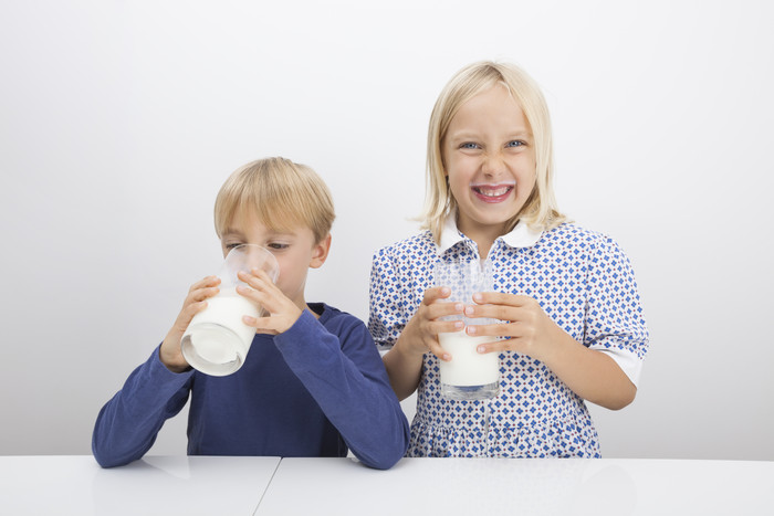 简约风格喝牛奶的孩子摄影图