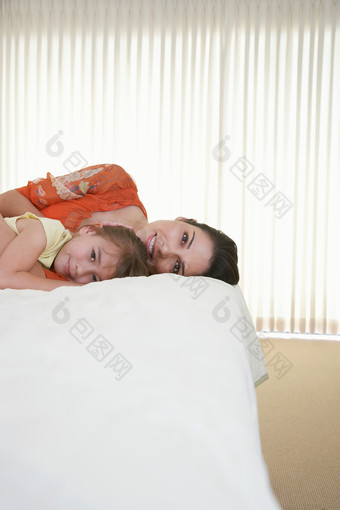 简约床上躺着的母女摄影图