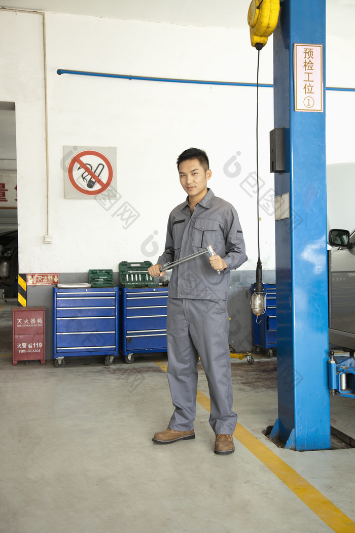 汽车维修店师傅男人工作拿着工具站着摄影图