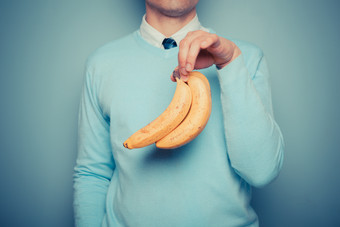 简约拿香蕉的人摄影图