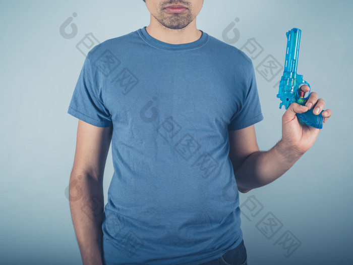 蓝色调拿玩具枪的男人摄影图