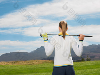 扛着高尔夫球杆的女人背影