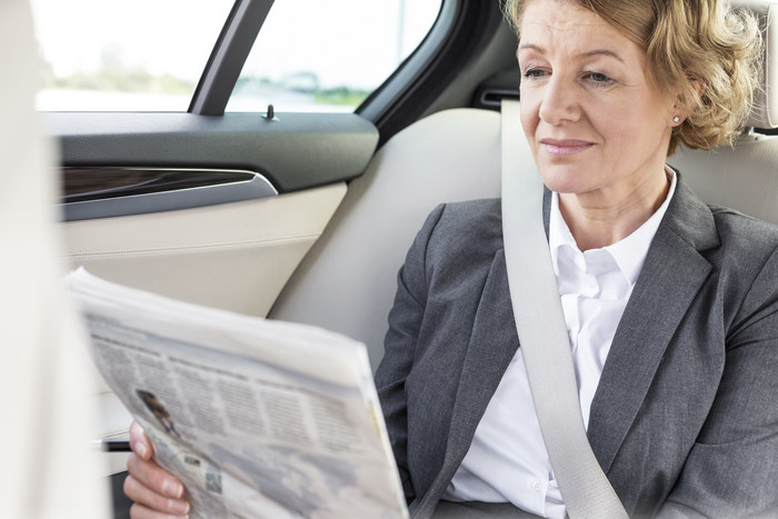 车里看报纸的商务女人