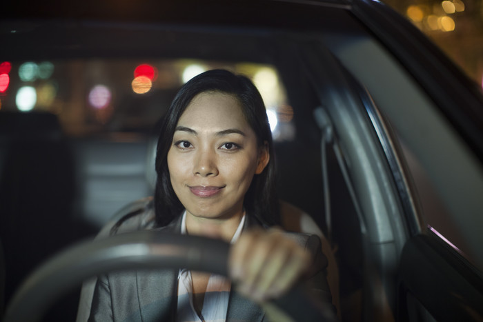 女人夜晚开车微笑城市下班白领工作车内摄影