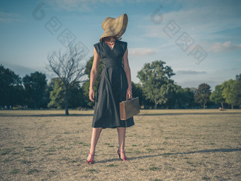 暗色调在草地散步的女人摄影图