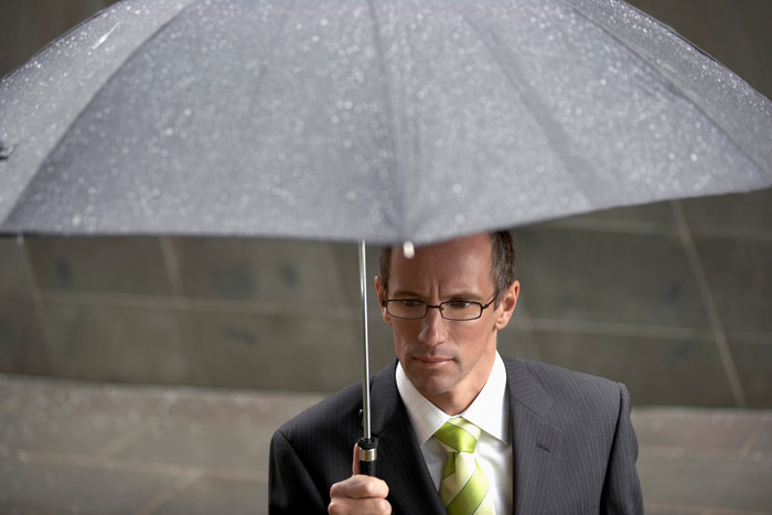 雨天撑雨伞的商务男人