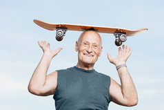 浅色调玩滑板的老人摄影图