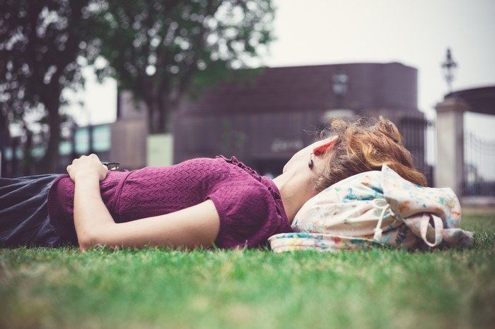 清新草地上睡觉的女人摄影图