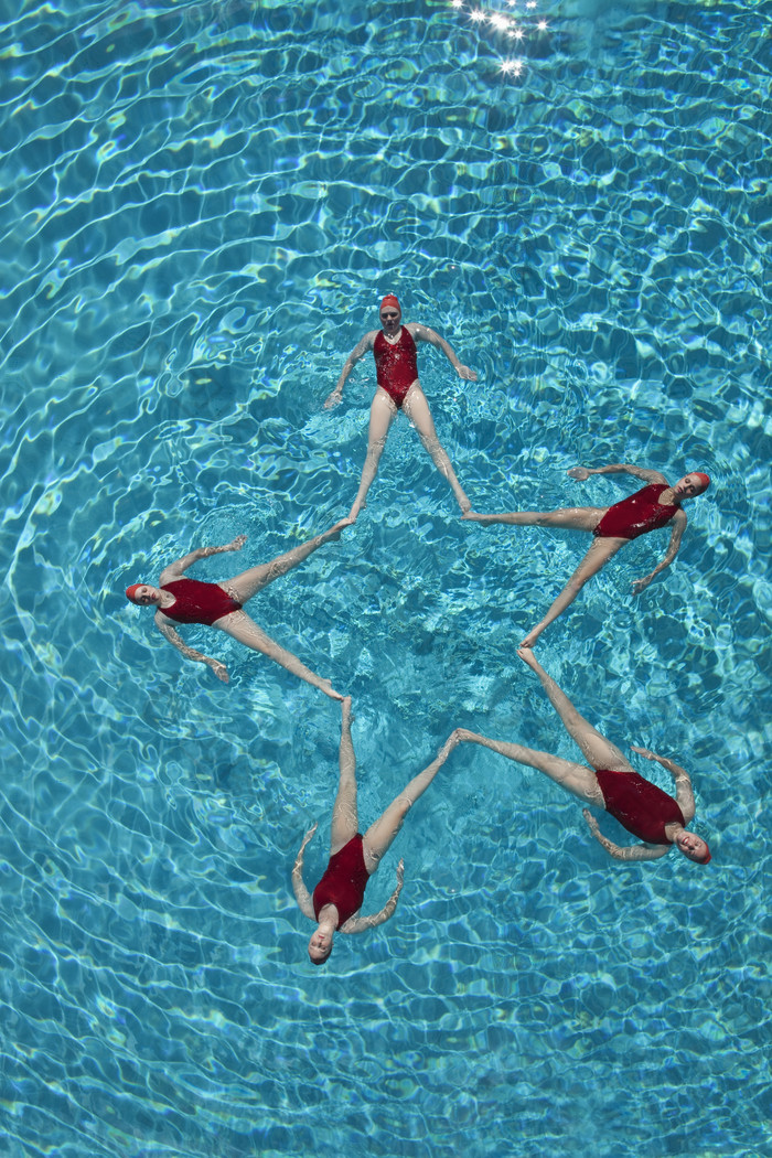 蓝色调泳池中表演的女孩摄影图