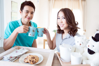夫妻情侣男人女人家庭吃早餐干杯微笑摄影图