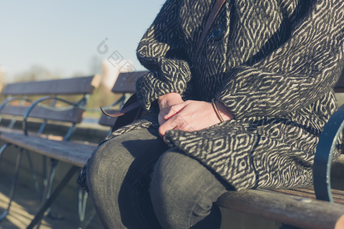 坐公园长椅上休息的女人摄影图