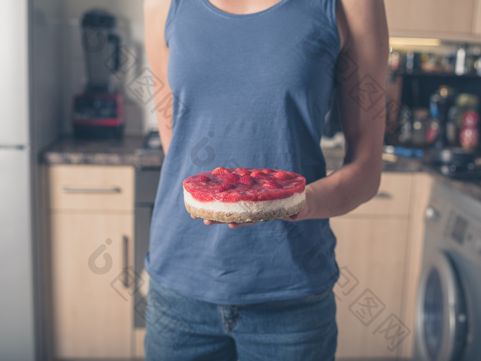 女人托着草莓芝士蛋糕