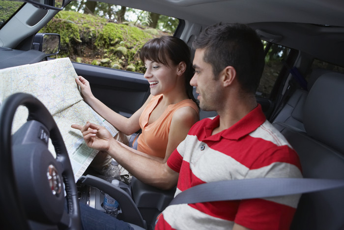 青年男女坐在车内看地图