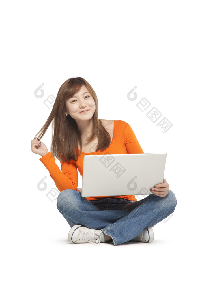 盘腿坐地上玩电脑的女孩