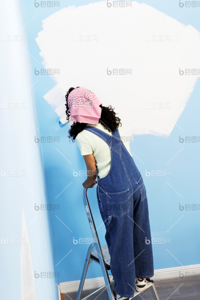 站在梯子上刷墙摄影图图片-包图网