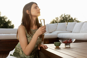 户外端着酒杯喝酒女人