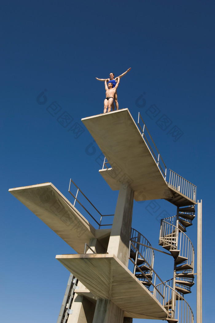 蓝色调高台跳水的两个人摄影图
