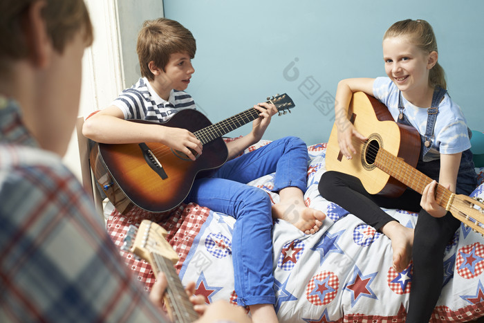儿童坐在床上弹吉他