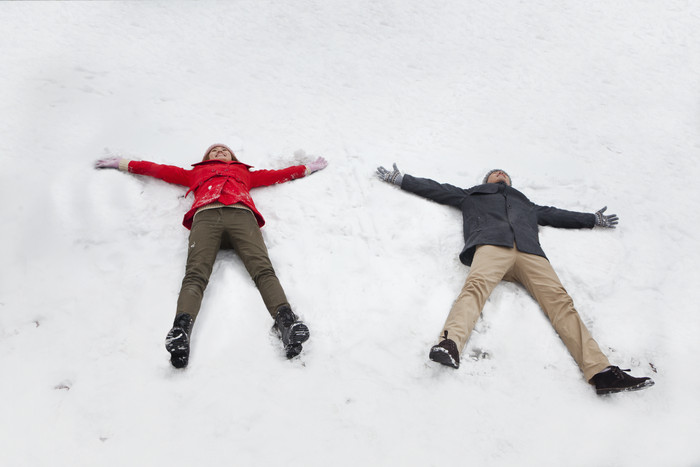 两个人男生女生躺雪地上冬天下雪休闲的摄影