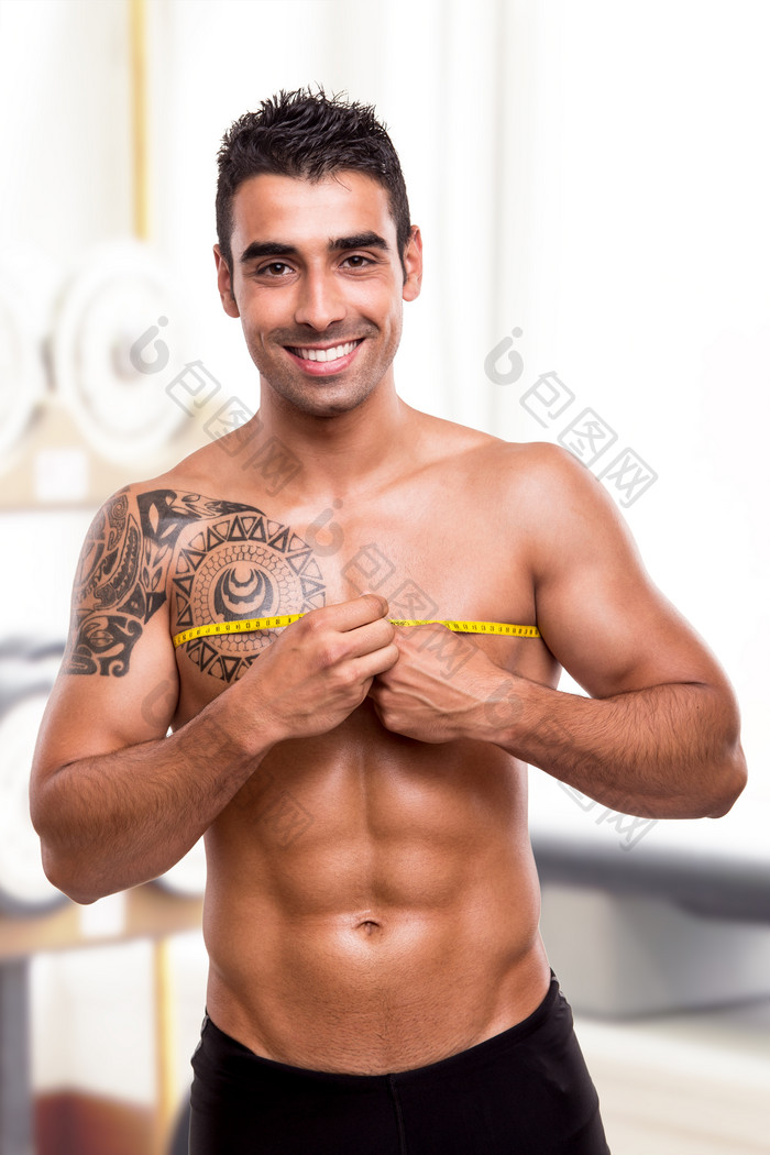 测量胸肌的男性摄影图