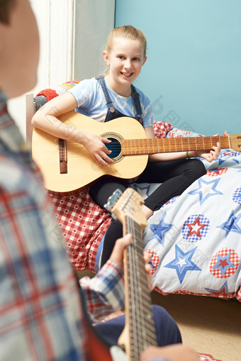 女孩坐在床上弹吉他