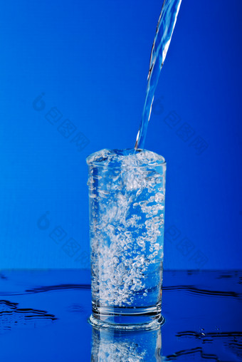 蓝色背景往杯子里倒水