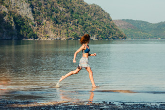 海滩上奔跑的女人摄影图
