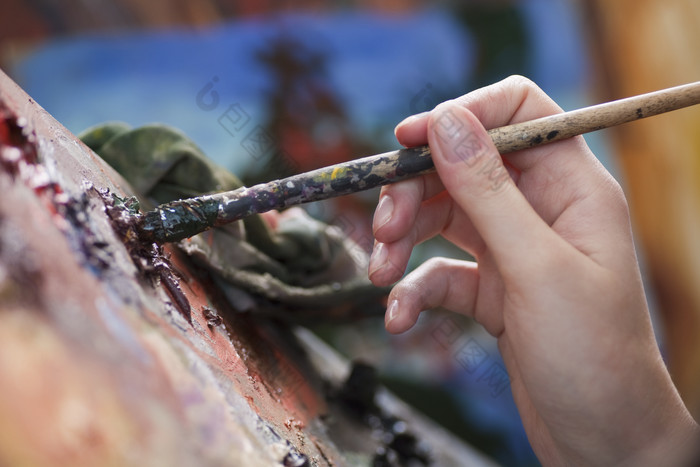 拿着画笔蘸颜料的画师
