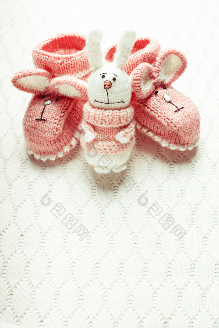 白色垫子上的手工兔子婴儿鞋