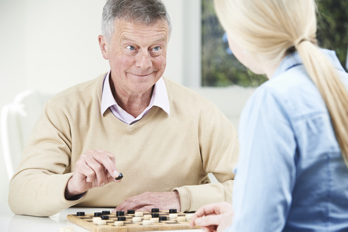 简约陪老人下棋摄影图