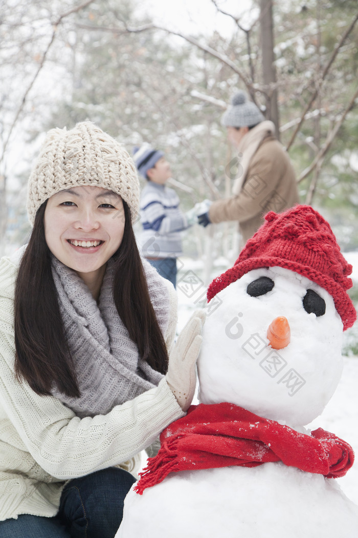 冬天堆雪人的女人摄影图