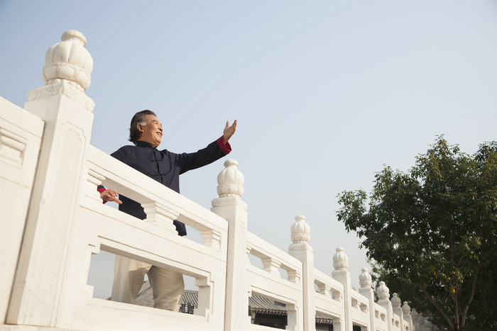 老年人男人爷爷户外桥上风景手势旅行摄影图