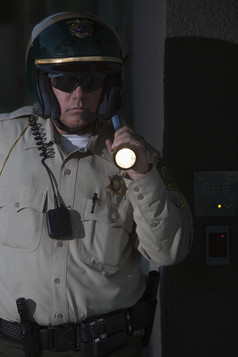暗色调拿着电筒的警察摄影图