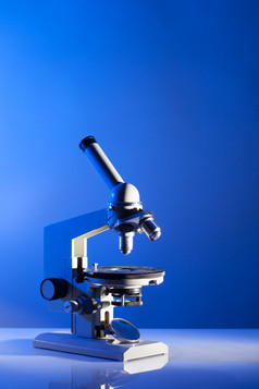 蓝色调桌上的显微镜摄影图