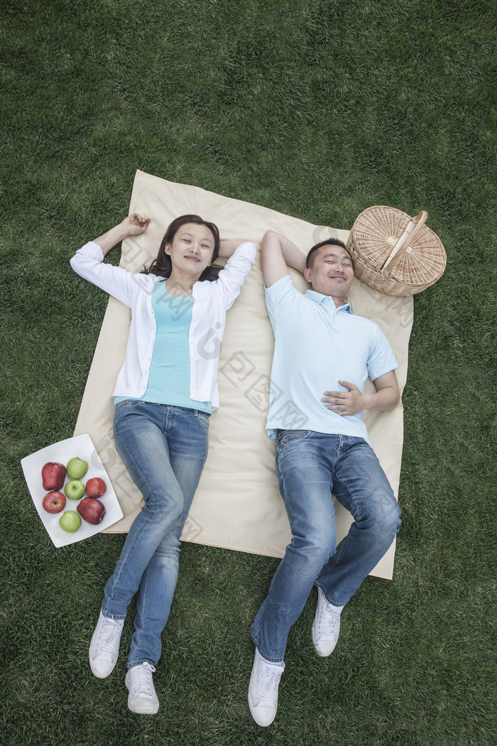 绿色调躺在草地上的情侣摄影图