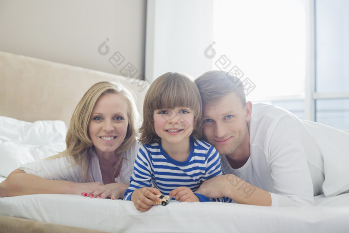 清新风床上的一家人摄影图
