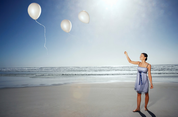 沙滩放飞气球的女人