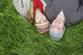 年轻情侣戴帽子躺在草坪