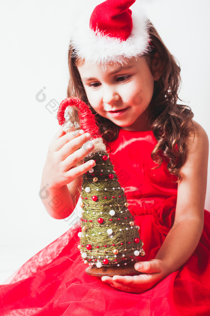 拿着圣诞树装饰物的小女孩