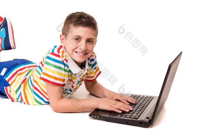 趴着玩电脑的男孩摄影图